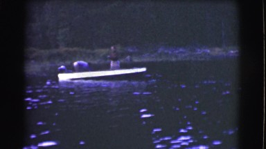 1951: two men lake fishing pulling their large catch into their boat. CANADA