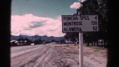 1967: distance sign at the edge of town notes the miles to other towns COLORADO