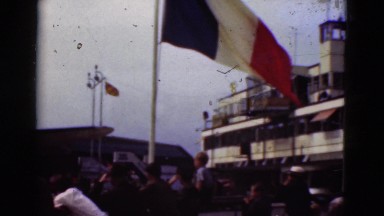 1948: big flags wave in the breeze on large court where people are gathered