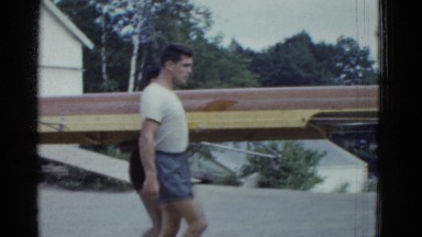 1951: four men carry rowboat to the water on summer day DANVILLE, ILLINOIS
