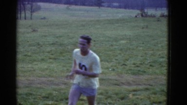 1951: adult man running in race outdoor on the grass with another person running