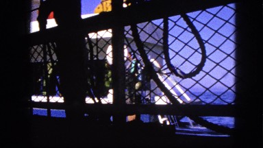 1963: ferry docking view through gated iron fence. CALIFORNIA