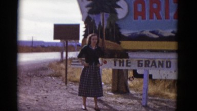 1952: young lady stands in front of "welcome to arizona" road sign ARIZONA