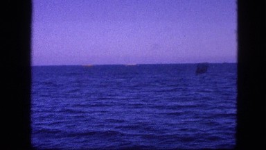1963: view of the ocean waves from moving boat with mountains