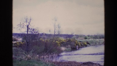 1969: a man standing in a beautiful river fly fishing ENGLAND