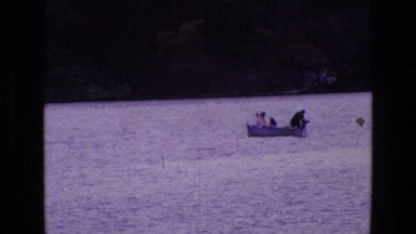 1969: three person sailing with a motor boat in a lake ENGLAND
