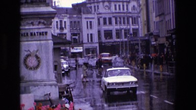 1969: cars and pedestrians moving through the wet road in a busy city IRELAND