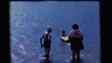 1963: a boy with floating rift in water and watched by two women CAMDEN