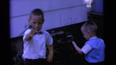 1963: two boys pull and show flowers from corner yard in front of house CAMDEN