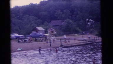 1963: men with children enjoying the coolness of the water in lake CAMDEN