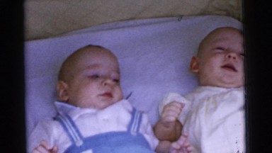 1961: Two Happy Infants in Bassinet Responding to Adult Attention DETROIT