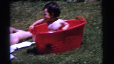 1961: mom giving bath to her baby in a tub at outdoors in a sunny day. DETROIT