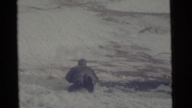 1963: a man lying on the snow and skating down fast along the hill CAMDEN, NEW