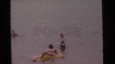 1963: kids playing at lake on inflatable rafts in summer CAMDEN, NEW JERSEY