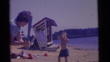 1963: children playing ball together at the lake on a beautiful sunny day.