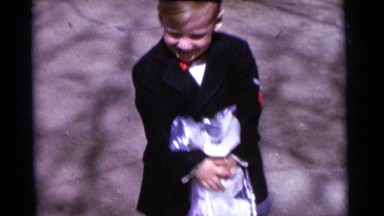 1963: a woman, two boys and a girl are dressed up, standing, and moving