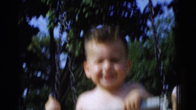 1961: Excited Happy Boy Swinging on Playground Swings Detroit, Michigan
