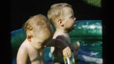 1961: two babies sit in the small pool on a hot summer day outside DETROIT