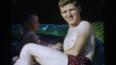 1961: a handsome young father playing with his boys in a small swimming pool