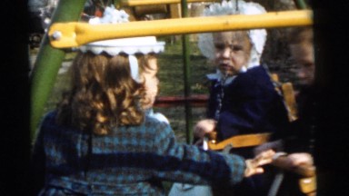 1961: bossy sister pushes siblings around on swings DETROIT, MICHIGAN