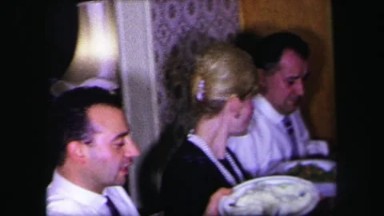 1974: family sits down for dinner and a woman steals bread from a tiny sailor