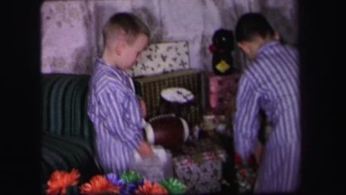 1974: kids in pajamas opening gifts from under a christmas tree LYNBROOK