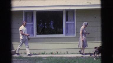1961: woman and man come outside to car with dog CLARKSDALE, ARIZONA