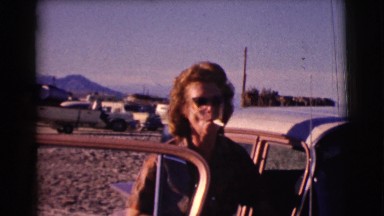 1961: lady standing by car enjoying the lake CLARKSDALE, ARIZONA