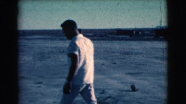 1961: a man in white dress leveling the ground with a short stick CLARKSDALE