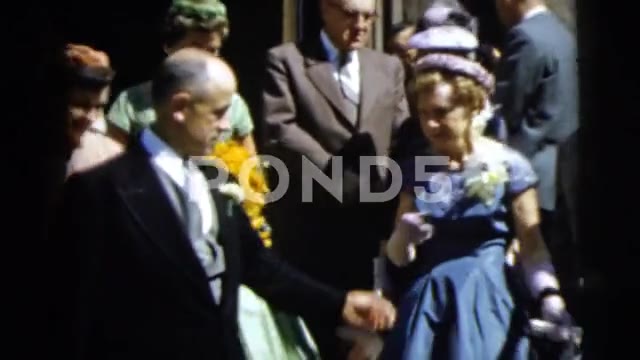 1962: Two Women Posing in Front of Light-Gray House While One Smokes