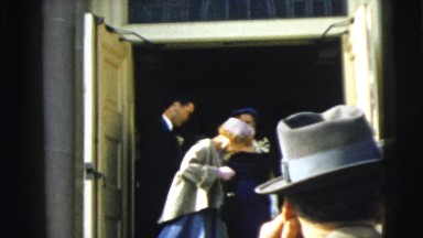 1962: at a church, a wedding party exits the building and waits for the bride