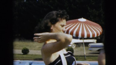 1962: two pretty brunettes at the poolside with towels wiping off and smiling.