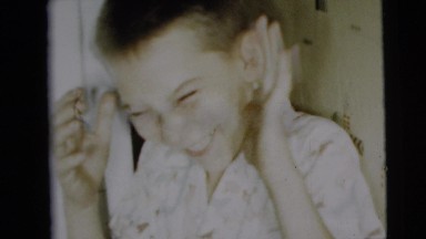 1962: boy laughing with man in the background CAMDEN, NEW JERSEY