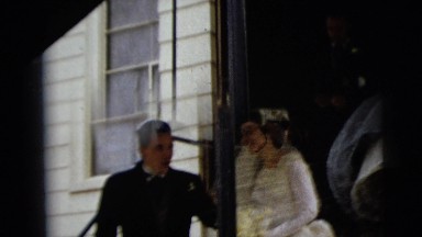 1962: bride steps down the entrance of a building