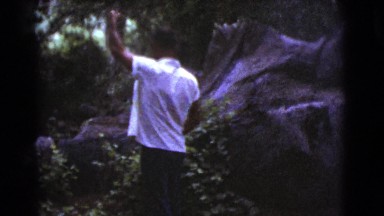 1964: a man in the woods raising his hand into the air and gesturing COTTONWOOD