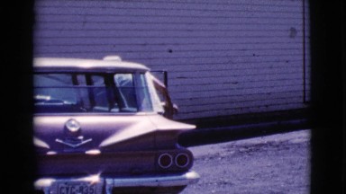 1964: a handsome young man getting out of the passenger side of a vehicle