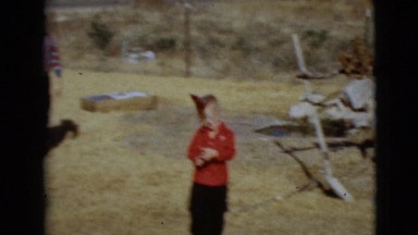 1968: a woman and boys outdoors running about with birthday hats CLARKSDALE