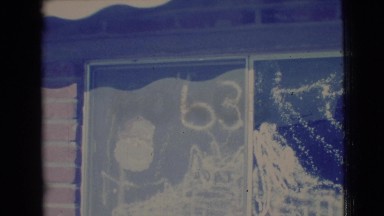 1968: children outside playing in front of a window decorated for the holidays