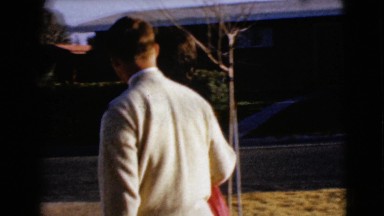 1968: an attractive couple walking to the car and the young man opens the car
