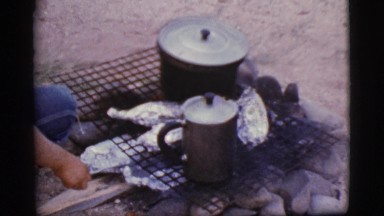 1968: camping out in the backyard while preparing food from a barbecue.