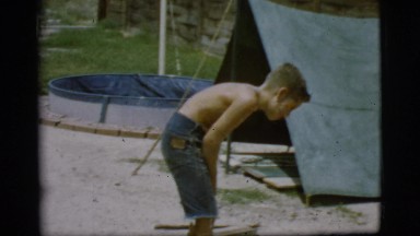 1968: young boy keeping a campfire going COTTONWOOD, ARIZONA