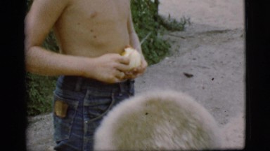 1968: young boy peeling an apple with a knife drops it and picks it up again