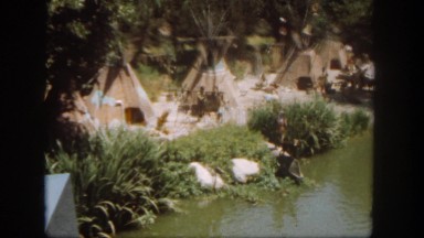 1962: a native-american village of tepees is located along a shoreline.