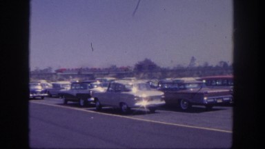1962: monorail nearby a parking lot with the train speeding off