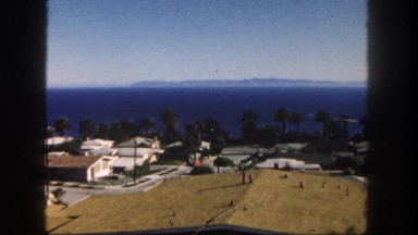 1962: a beautiful view of the ocean coastline beyond the various roof tops