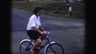 1958: man rides bicycle barefoot around the street in his neighborhood and comes