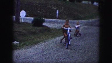 1958: a topless kid is seen on a bike AMES, IOWA