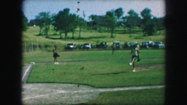 1958: women players are practicing baseball in the grassy ground AMES, IOWA