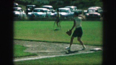 1958: boy pitching ball in green grass near parking lot AMES, IOWA