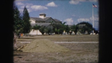 1958: a person in white dress walking through a deserted vast ground AMES, IOWA